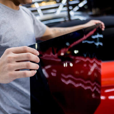 Applying Tinting Foil On A Car Window In A Auto Service